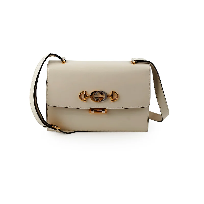 Women Gucci Sylvie bags with a detachable ribbon detailGucci Lock Logo Cream Crossbody Bag